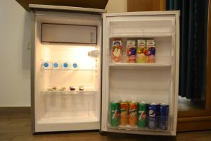 an open refrigerator filled with drinks and soda at Palace Court in Cairo
