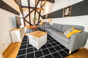 a living room with a couch and a tv at The FULL HOUSE Loft in Halle an der Saale