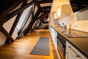 a kitchen with white cabinets and a floor with wooden floors at FullHouse - Halle - R17 - 111sqm Loft - 8 Beds for 10 guests in Halle an der Saale +33 photos