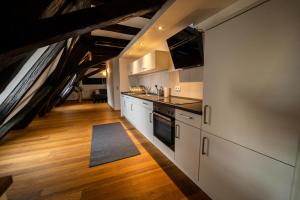 a kitchen with white cabinets and an attic at The FULL HOUSE Loft in Halle an der Saale