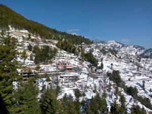 a village on a mountain covered in snow at Green view Guest House in Murree