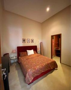 a bedroom with a large bed with a red bedspread at Villa lumias in Marrakesh