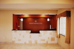 a lobby with a westwood inn sign on the wall at Westwood Inn & Suites in Gonzales