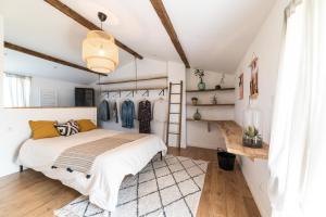 een slaapkamer met een bed in een kamer met witte muren bij Gîtes Les Pittoresques in Saint-Jean-Saint-Maurice-sur-Loire