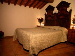 1 dormitorio con 1 cama con cabecero de madera en Agriturismo Ca' Lucano, en Arezzo