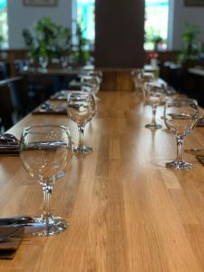 una fila de copas de vino sentadas en una mesa de madera en A Fogadó, en Bicske