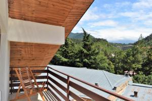 a wooden chair sitting on the balcony of a house at Gogichas tower in Borjomi