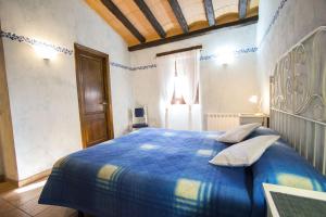 um quarto com uma cama azul com almofadas em Catalunya Casas Sublime seclusion in Catalonia wine Region! em Juncosa