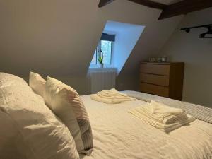 a bed with white sheets and pillows in a bedroom at Willow House - 2bed Townhouse with free parking!! by Shortstays4U in King's Lynn