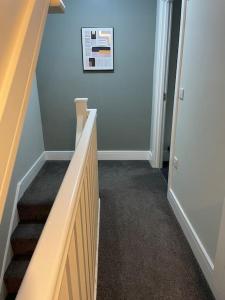 un pasillo con escaleras y una foto en la pared en Willow House - 2bed Townhouse with free parking!! by Shortstays4U en Kings Lynn