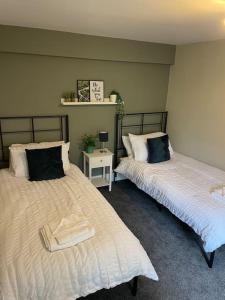 dos camas sentadas una al lado de la otra en una habitación en Willow House - 2bed Townhouse with free parking!! by Shortstays4U en Kings Lynn