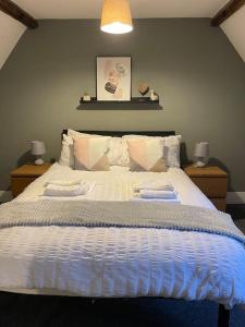 a bedroom with a large bed with two towels on it at Willow House - 2bed Townhouse with free parking!! by Shortstays4U in King's Lynn