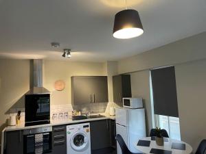 a kitchen with a refrigerator and a washer and dryer at Willow House by Shortstays4U 2bedroom Townhouse with free parking in town centre! in King's Lynn