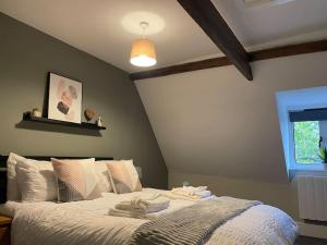 a bedroom with a bed with towels on it at Willow House by Shortstays4U 2bedroom Townhouse with free parking in town centre! in King's Lynn