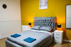 ein Schlafzimmer mit einem Bett mit zwei blauen Handtüchern darauf in der Unterkunft AJB INTERNATIONAL LTD in London