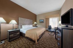 a hotel room with a bed and a flat screen tv at Baymont by Wyndham Lawrence in Lawrence