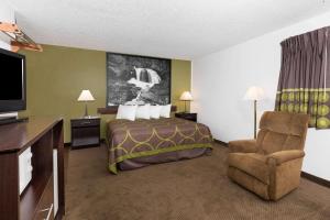 ein Hotelzimmer mit einem Bett und einem Stuhl in der Unterkunft Super 8 by Wyndham Missoula/Brooks Street in Missoula
