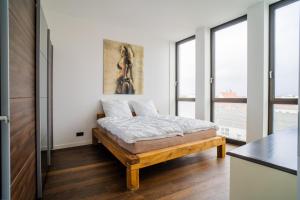 a bedroom with a bed in a room with windows at Panorama Bliss - Luxus Apartment in Braunschweig's Altstadt in Braunschweig