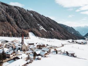 ein schneebedecktes Dorf mit einem Berg im Hintergrund in der Unterkunft Familienhotel Huber in Vals