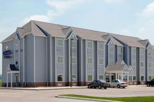 a large building with cars parked in a parking lot at Microtel Inn & Suites by Wyndham Delphos in Delphos