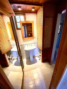 ein Badezimmer mit 2 Waschbecken und einem Spiegel in der Unterkunft Casa Saurel en La Cascada in San Martín de los Andes
