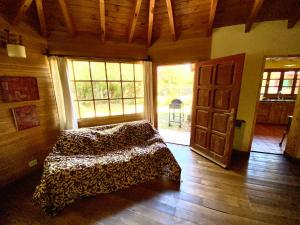 Habitación con cama y puerta abierta en Casa Saurel en La Cascada en San Martín de los Andes