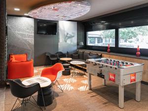 - une salle de jeux avec une table de baby-foot et des chaises dans l'établissement Hotel Ibis Milano Ca' Granda, à Milan