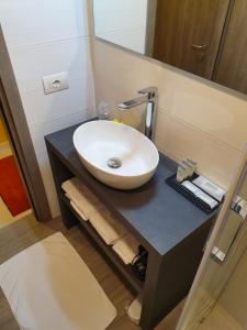 een badkamer met een witte wastafel en een spiegel bij Al Santuario in San Vito al Tagliamento