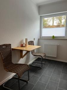 uma mesa e cadeiras num quarto com uma janela em F&M Wohnungen in Olpe em Olpe