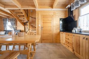 a kitchen with a wooden table and a dining room at Góralskie Domki Zakopane Gubałówka in Zakopane