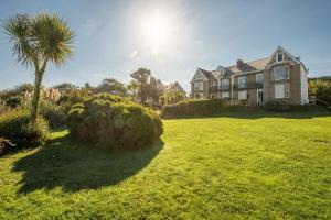 a large house with a palm tree in a yard at Keynvor Blue, Carbis Bay, St Ives in St Ives