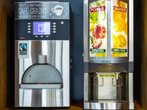 - une machine à café à côté d'une boîte de jus d'orange dans l'établissement ibis budget Saint Dié des Vosges, à Saint-Dié-des-Vosges