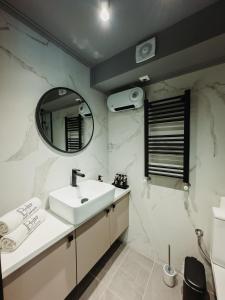 uma casa de banho com um lavatório e um espelho em BLACKHAUS FAMILY AND FRIENDS DELUXE APARTMENT em Tessalônica