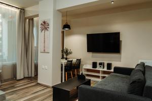 een woonkamer met een bank en een flatscreen-tv bij BLACKHAUS FAMILY AND FRIENDS DELUXE APARTMENT in Thessaloniki
