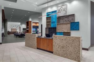 an office lobby with a reception counter with blue accents at Hyatt Place Athens Downtown in Athens