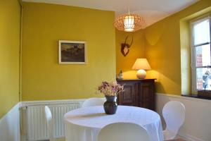 a dining room with a white table and chairs at Chateau de Vaux in Yvré-lʼÉvêque