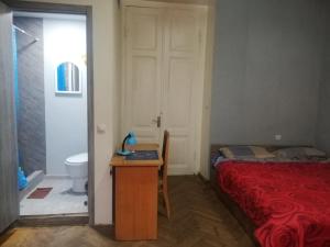 a bedroom with a bed and a desk and a toilet at Jessi on Marjanishvili in Tbilisi City