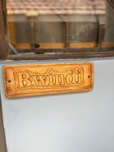 um sinal de madeira que diz biryani numa janela em 30 Wilson em Jinja