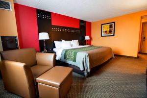 a hotel room with a bed and a chair at Travelodge by Wyndham Absecon Atlantic City in Absecon