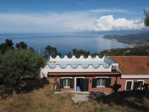 uma casa numa colina com vista para a água em Casa Gioiosa em Gioiosa Marea