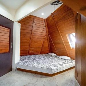 een groot bed in een kamer met een houten muur bij susil house villa in Vellore