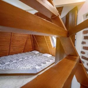 een leeg bed in een kamer met houten planken bij susil house villa in Vellore