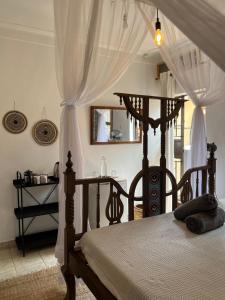 a bedroom with a wooden bed with a canopy at 30 Wilson in Jinja