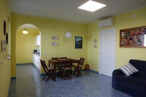 uma cozinha e sala de jantar com mesa e cadeiras em Casa Gioiosa em Gioiosa Marea