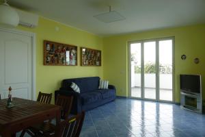 uma sala de estar com um sofá azul e uma mesa em Casa Gioiosa em Gioiosa Marea