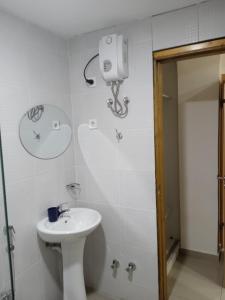 La salle de bains est pourvue d'un lavabo blanc et de toilettes. dans l'établissement Pull Up, à Praia