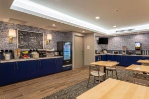a restaurant with blue cabinets and tables and a kitchen at AmericInn by Wyndham San Angelo in San Angelo