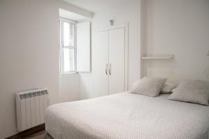 Habitación blanca con cama y ventana en Sensacional Apartamento Saladina Home, en Ourense