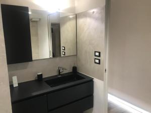 een badkamer met een zwarte wastafel en een spiegel bij Eliver's House in Bologna