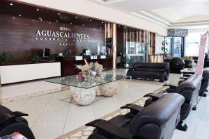 a salon with a glass table and leather chairs at Wyndham Garden Aguascalientes Hotel & Casino in Aguascalientes